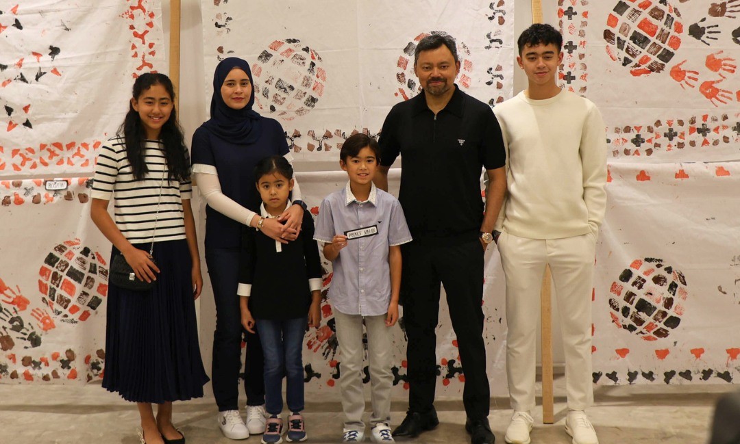 A family poses for a photo during a school cultural event.
