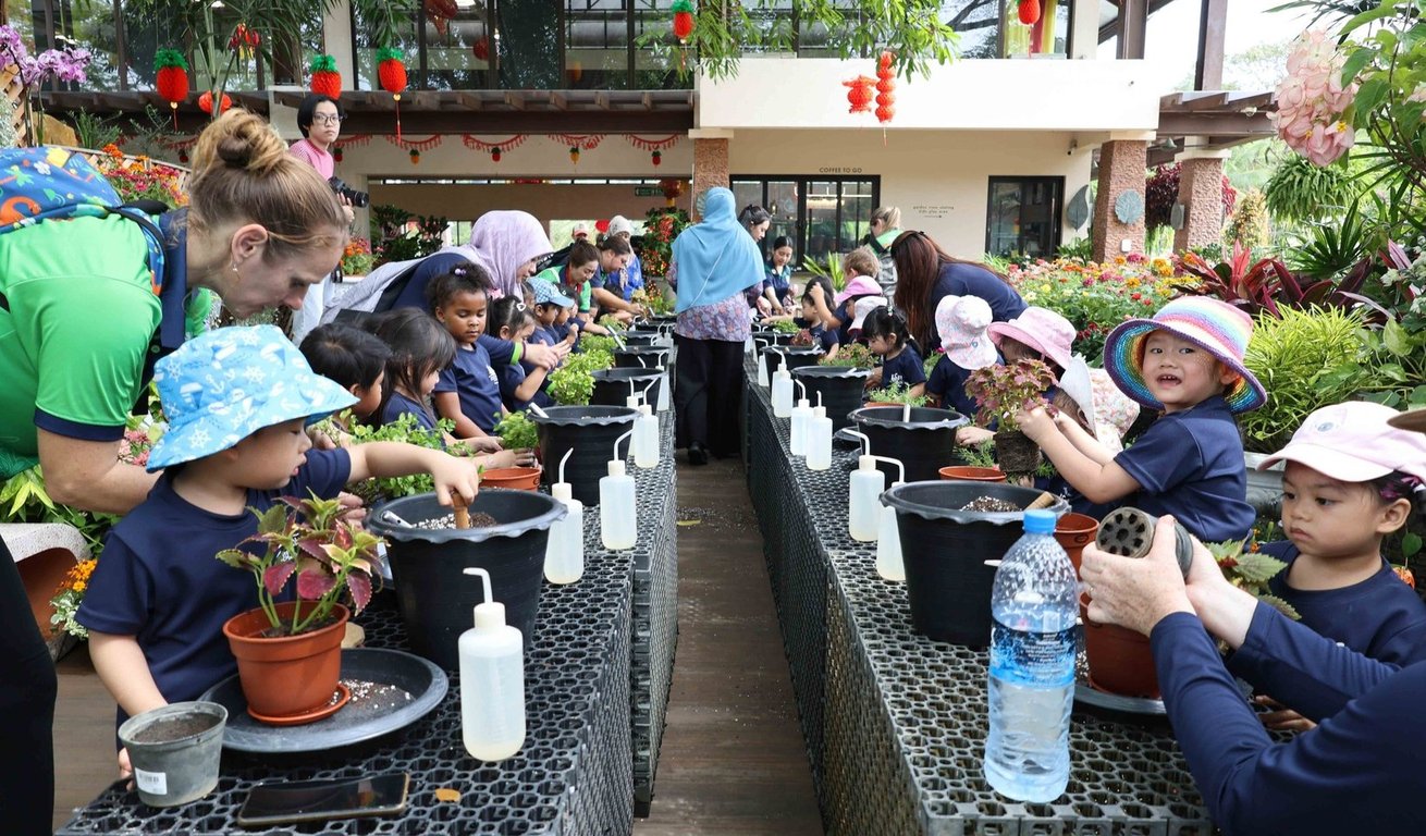 Students work together in a school garden, planting flowers and herbs as part of an environmental education initiative.