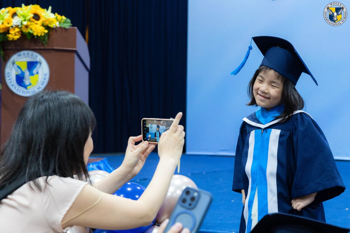 K3 graduate posing while parent takes a picture.