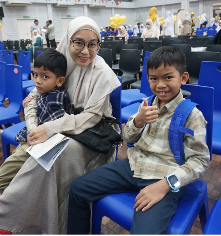 A parent with children attending the school’s Prize Giving Ceremony.