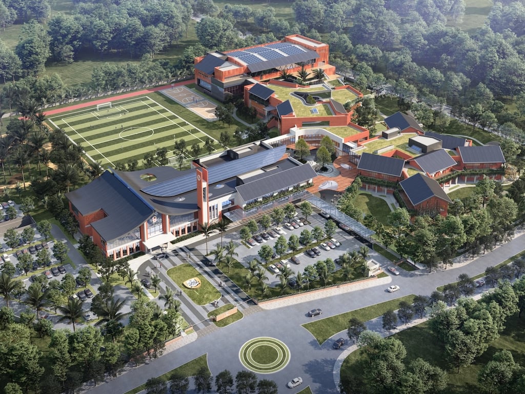 An aerial view of the Dulwich College Bangkok campus shows facilities, including sports fields, green roofs, and purpose-built learning spaces.