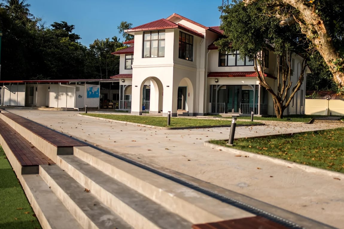 An exterior view of the school’s classical white academic building and landscaped grounds.