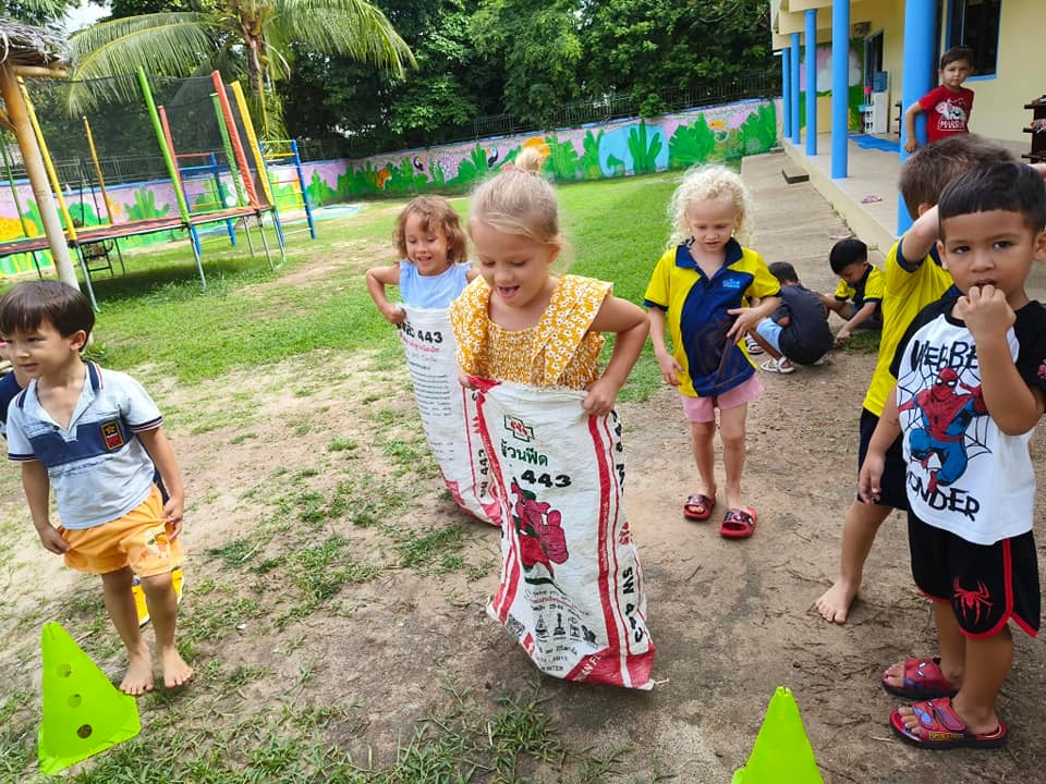 Children participating in a sack race during outdoor play.