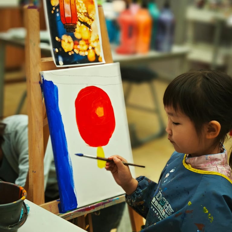 Student painting a lantern during the DSHK Temple Fair art activity.