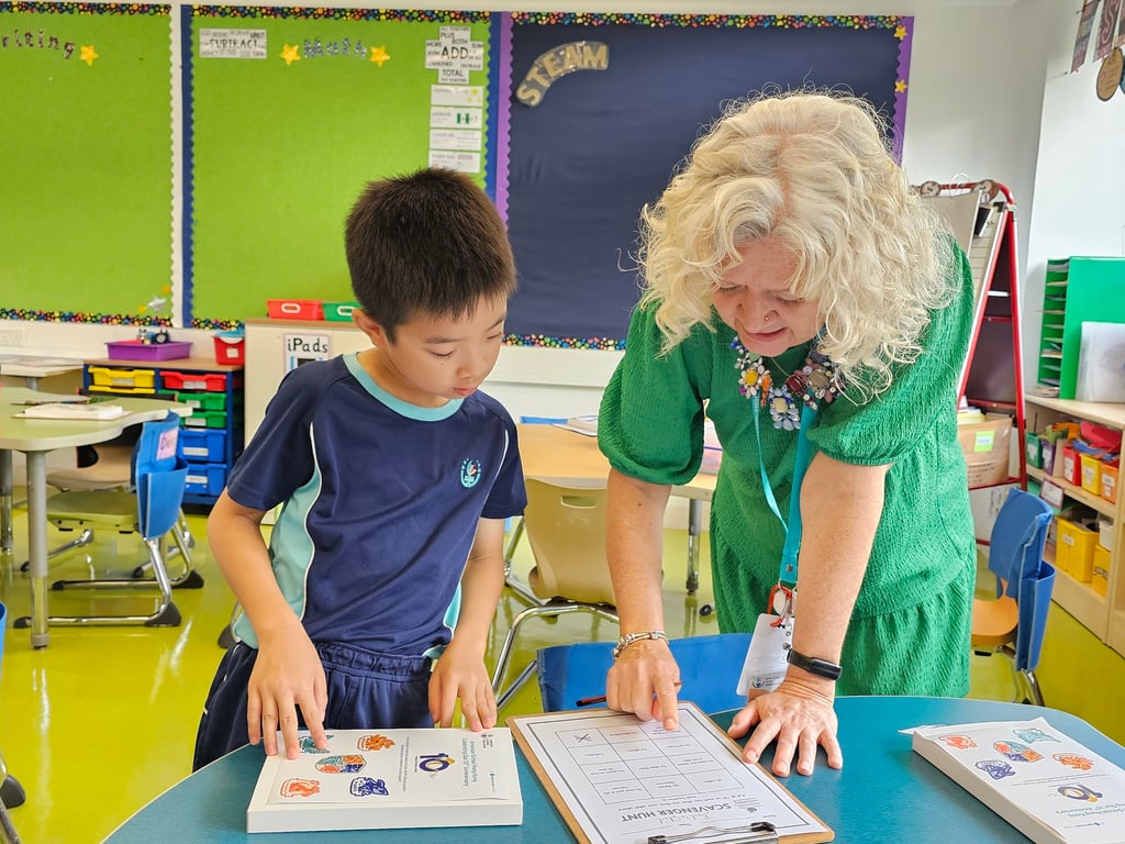 Teacher guiding student through a classroom scavenger hunt activity.