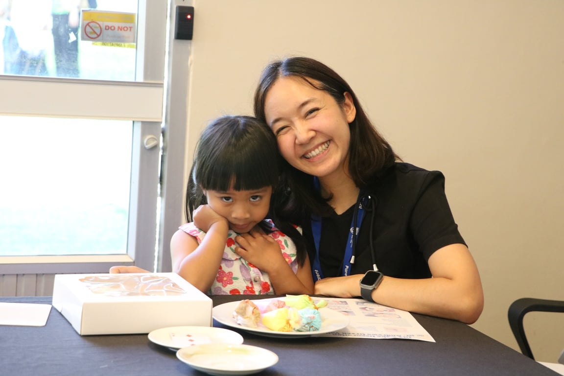 Parent and child enjoying time together at the cake decorating workshop.