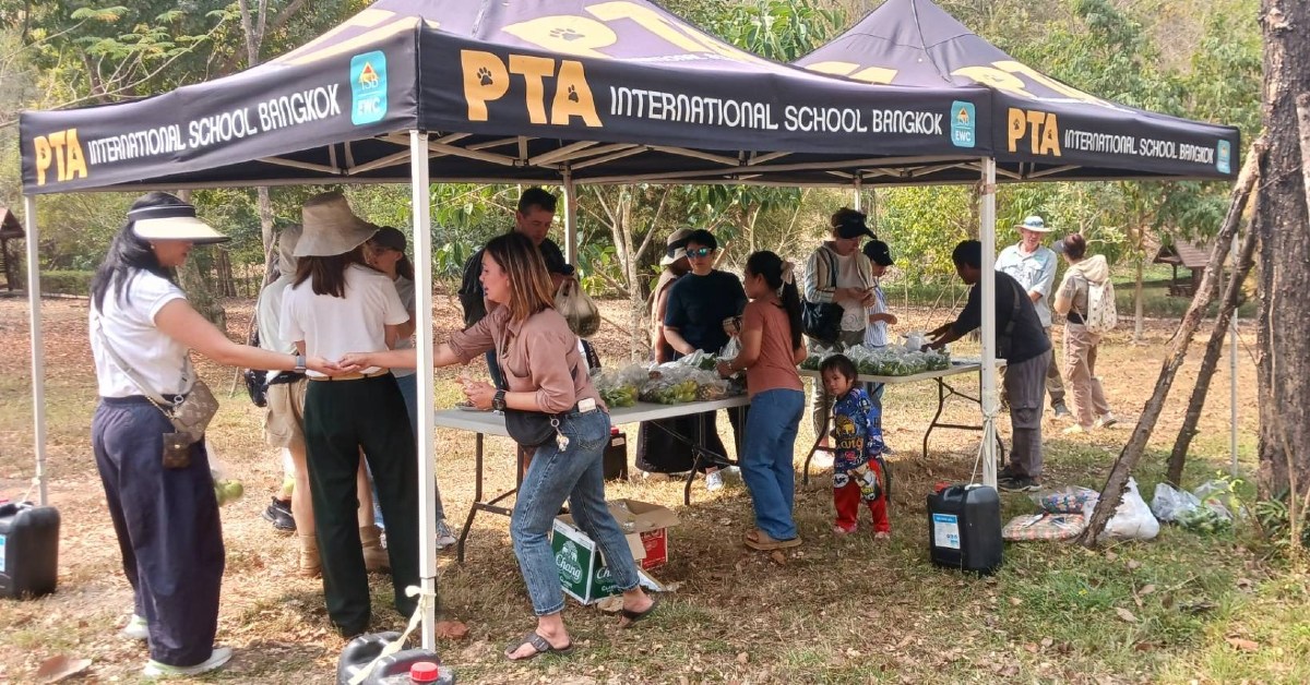 Parents volunteering at a PTA booth.
