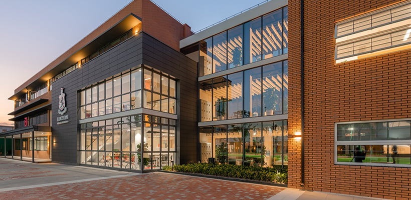 The modern glass and brick exterior of the Lucton School Shanghai campus.