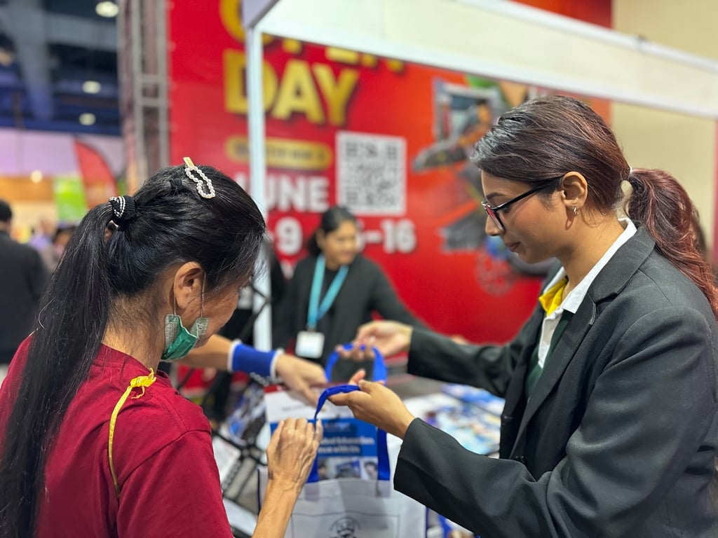 Student representative welcoming visitors at the Education and Further Studies Fair.