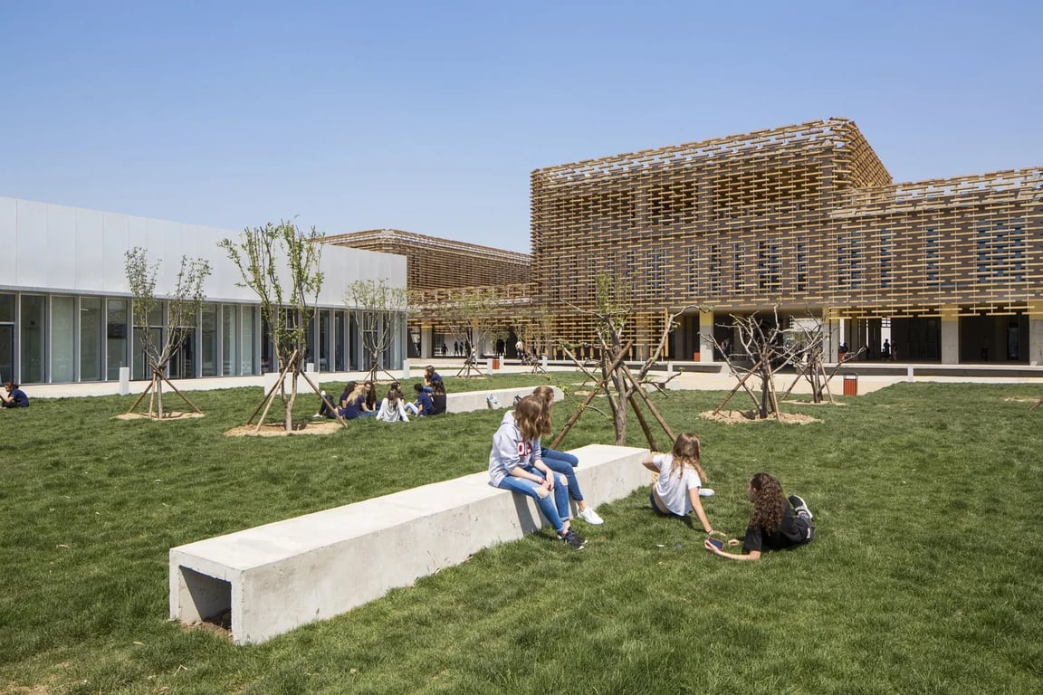 Students relaxing in the green courtyard of Lycée Français International Charles de Gaulle de Pékin.