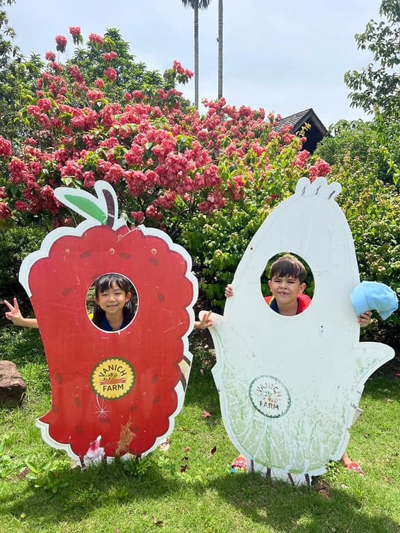 Students posing at a photo board during a farm visit.