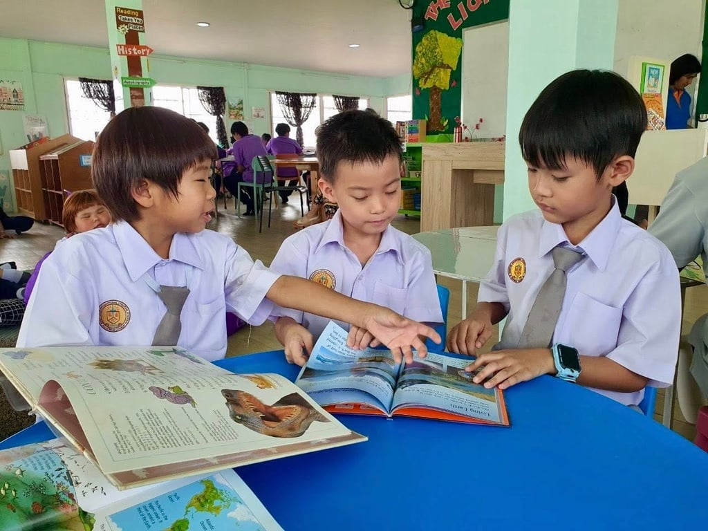 Primary students reading books in the library.