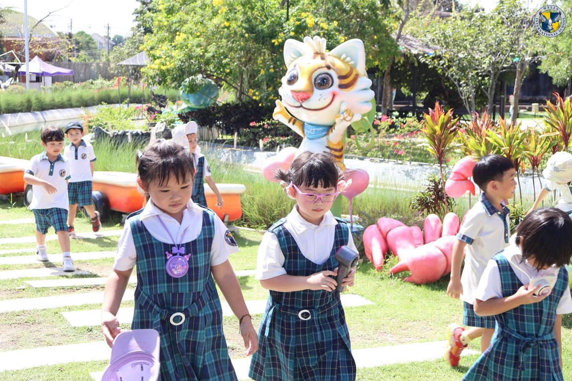 Kindergarten students walking through the zoo garden area.