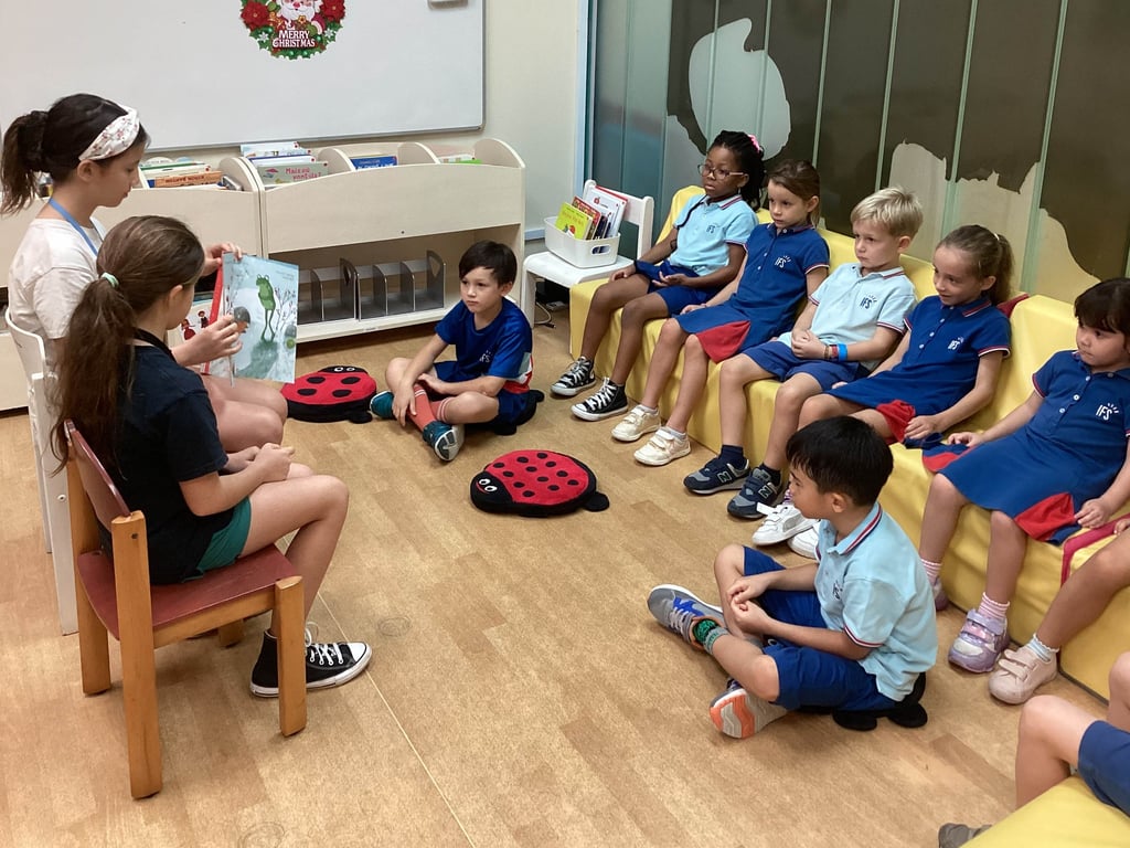 Older students join in with a Library Initative by reading books to the Kindergarten students
