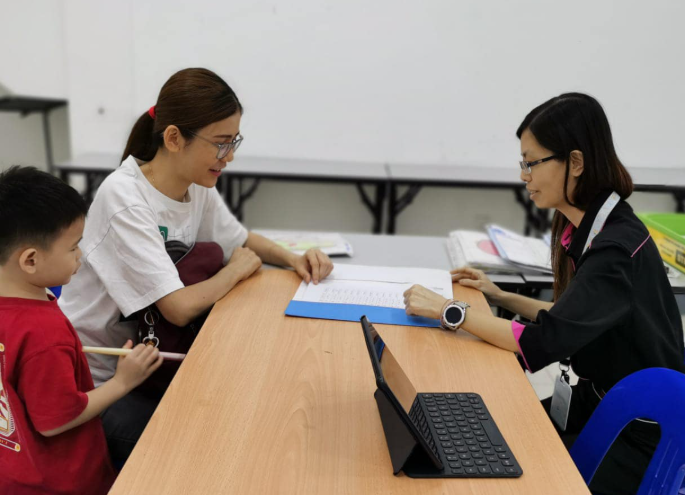 A parent discussing with a teacher on parent's day. 