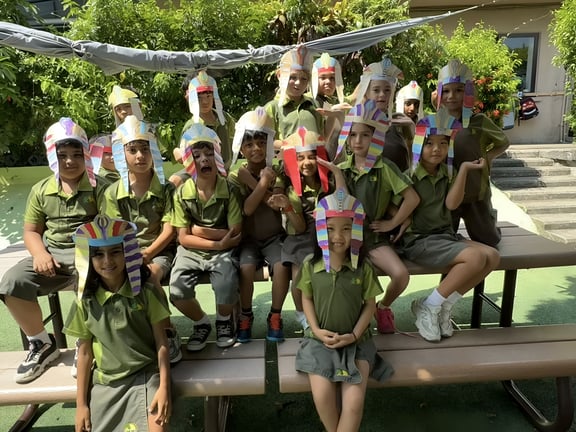 Students wearing handmade Egyptian-style headpieces during a themed classroom activity.