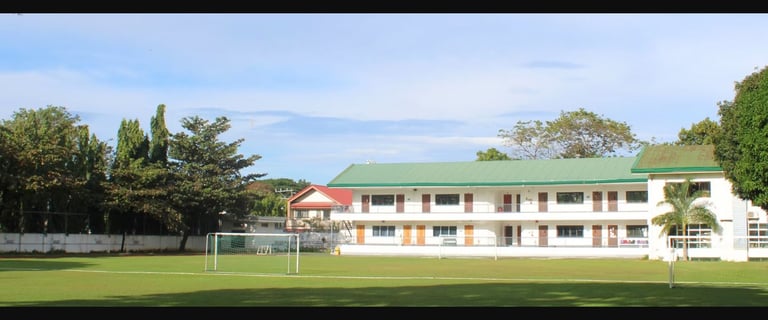 The school building overlooking the school's expansive green sports field.