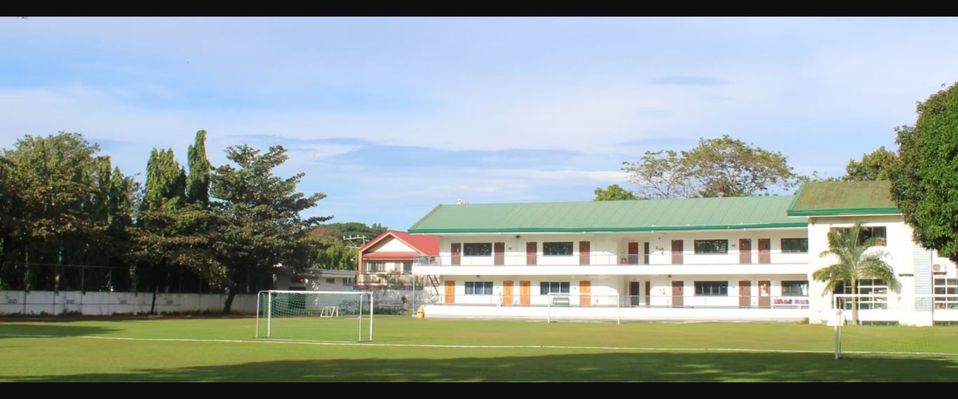 The school building overlooking the school's expansive green sports field.