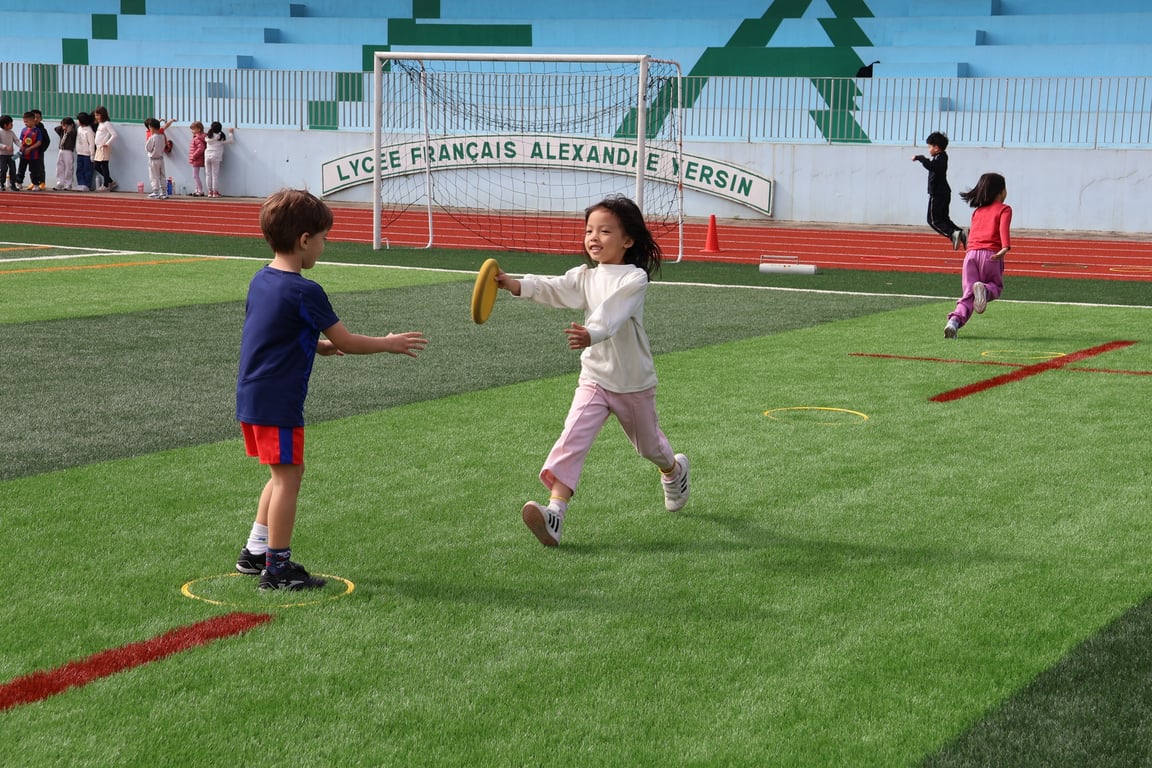 Young students playing a running game on the school field.