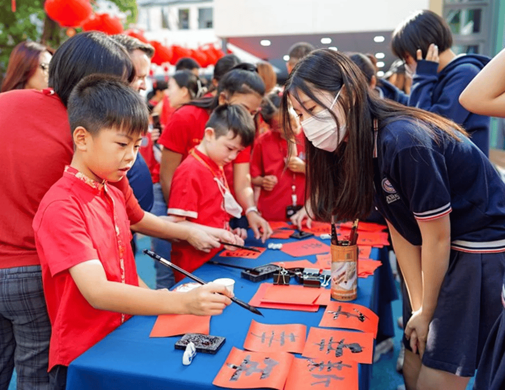 Cultural station featuring Chinese calligraphy at the school celebration.