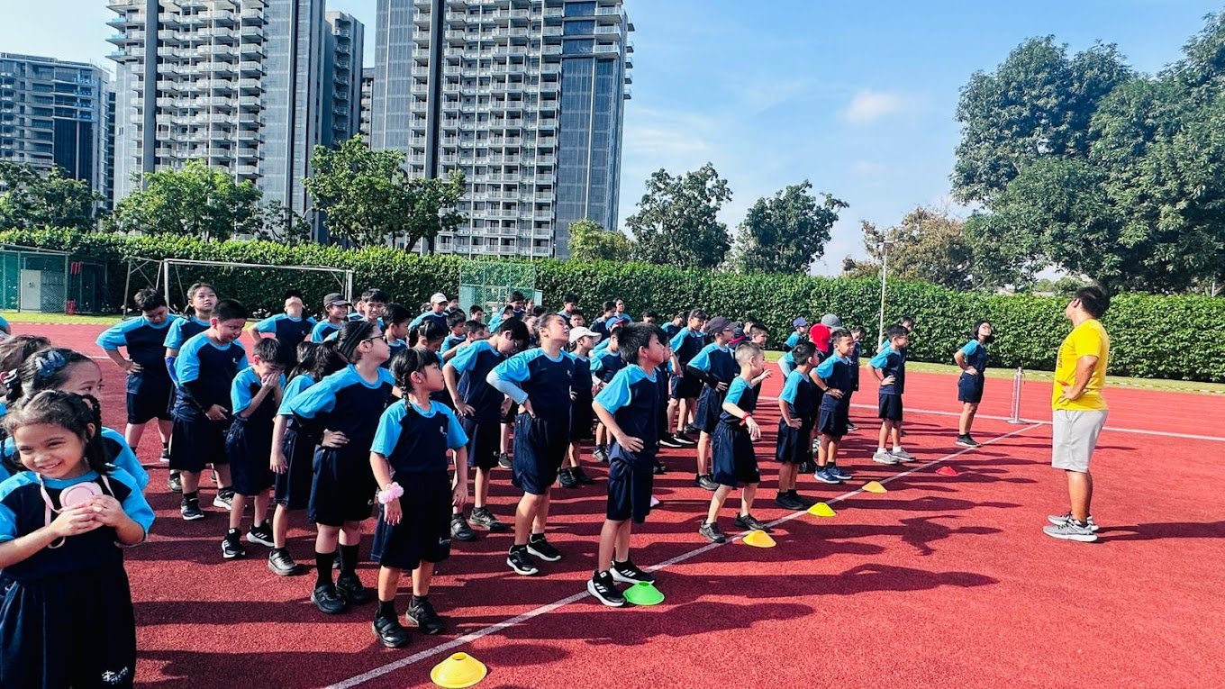 Students lining up for a physical activity on the sports pitch