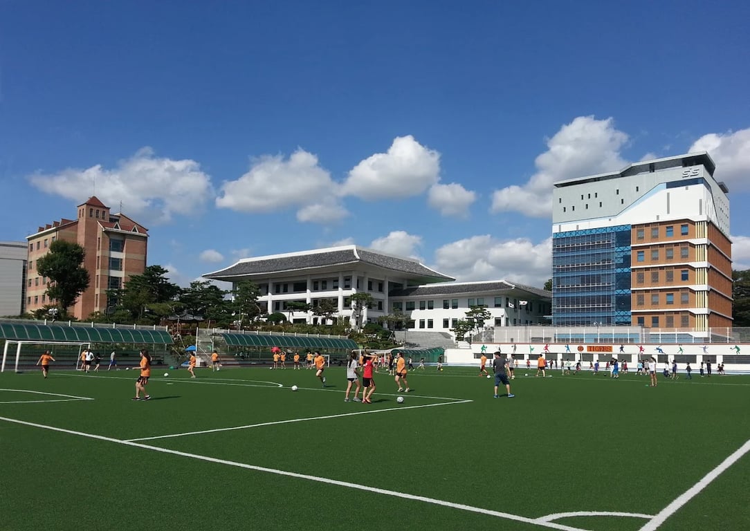 Exterior view of Seoul International School overlooking an athletic field.