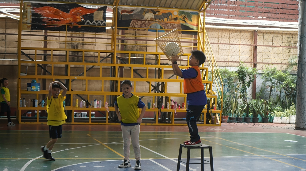Children play a fun basketball activity in the gym.