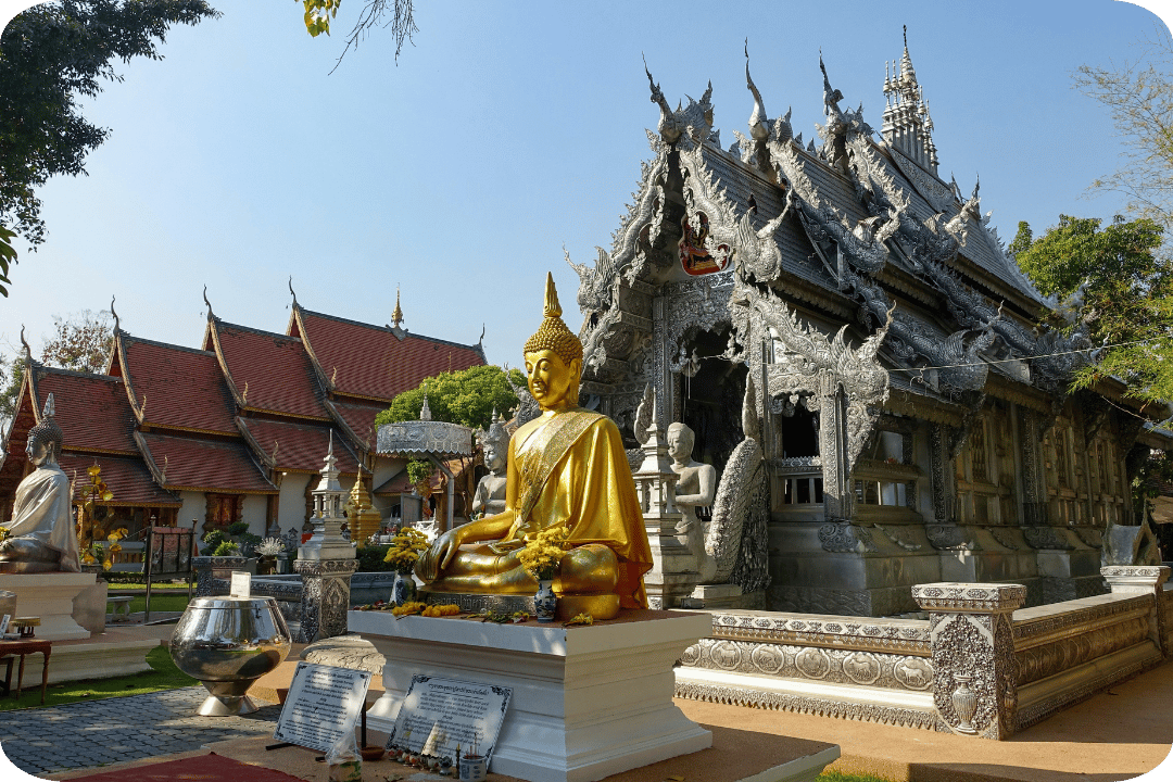 A temple with a golden buddha statue in front.