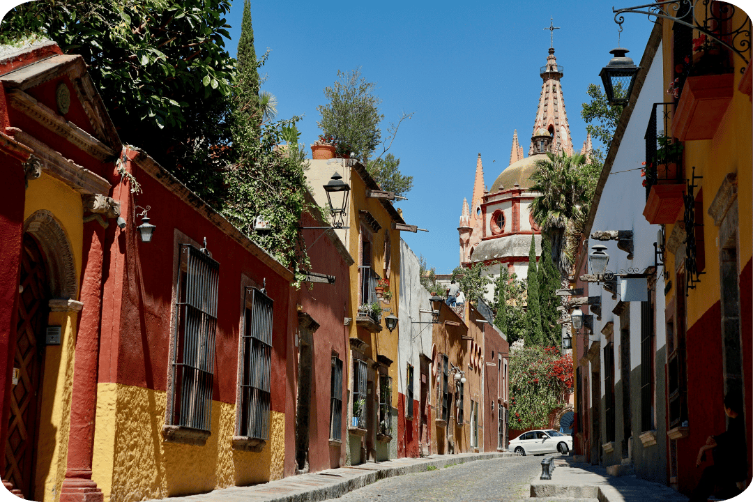 A vibrant street in Mexico with orange and yellow buildings.