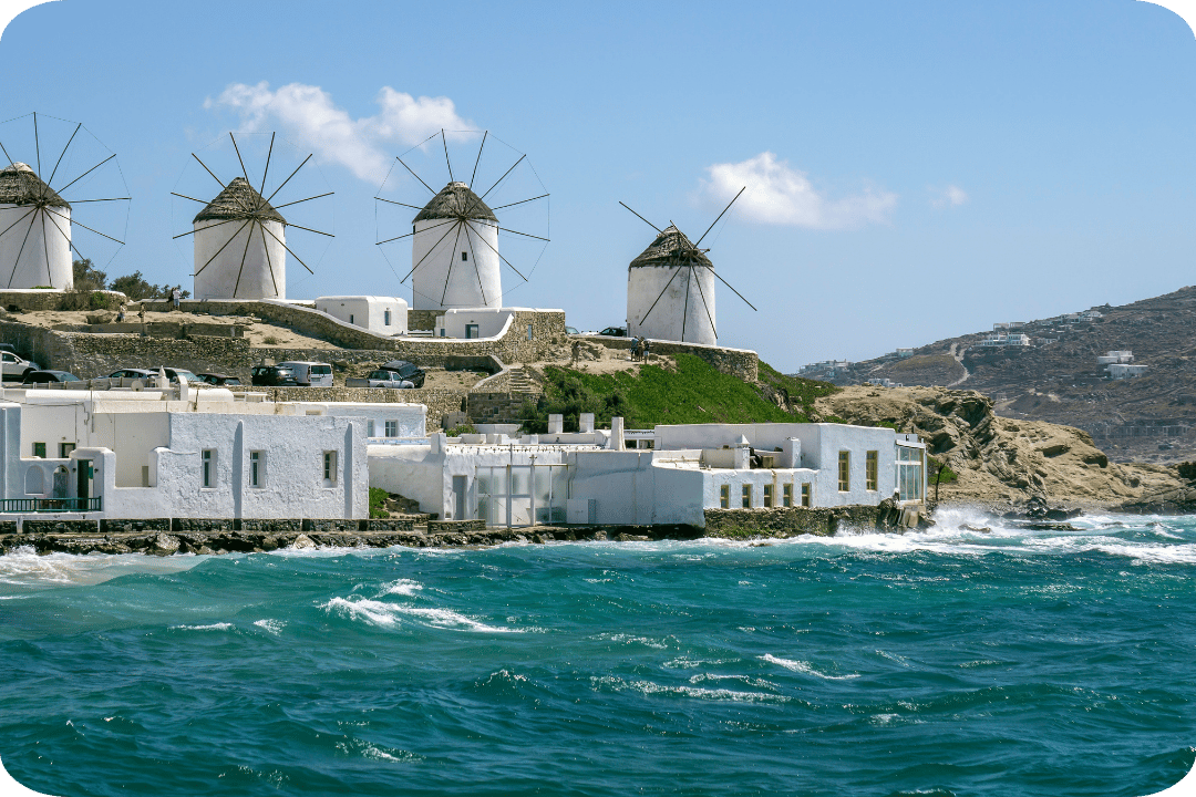 white buildings with windmills on the coast