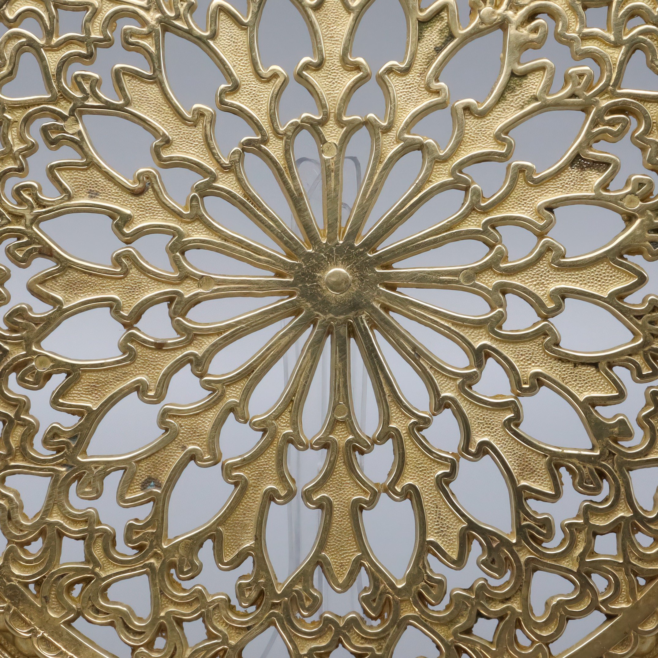 Antique brass trivet detailed view showing ornate vintage metalwork design