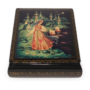 Russian lacquer box detailed view with hand-painted fairy tale princess and village scene