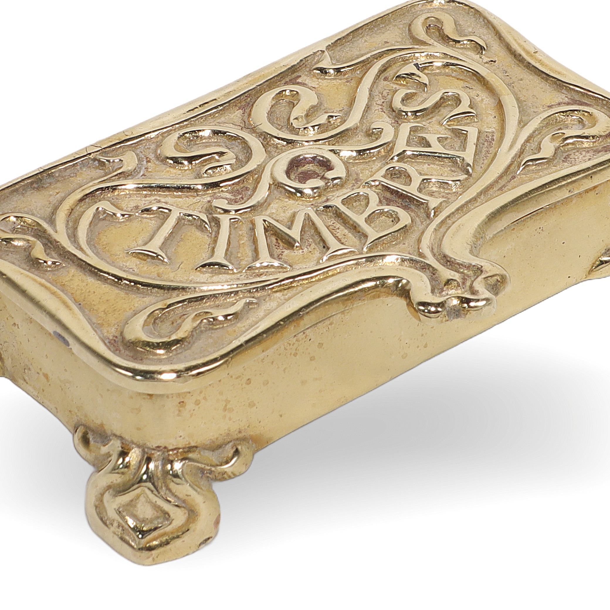 Brass stamp box close up with ornate design and "Timbres" engraving, antique collectible stationery accessory
