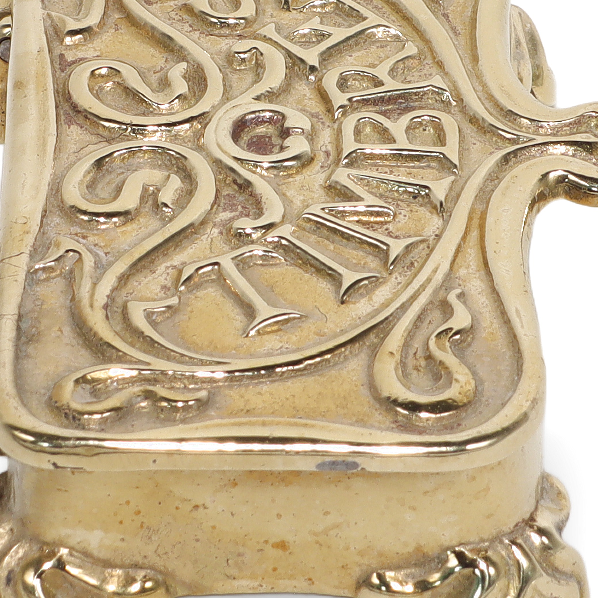 Brass stamp box close up showing ornate vintage design and engraved lettering