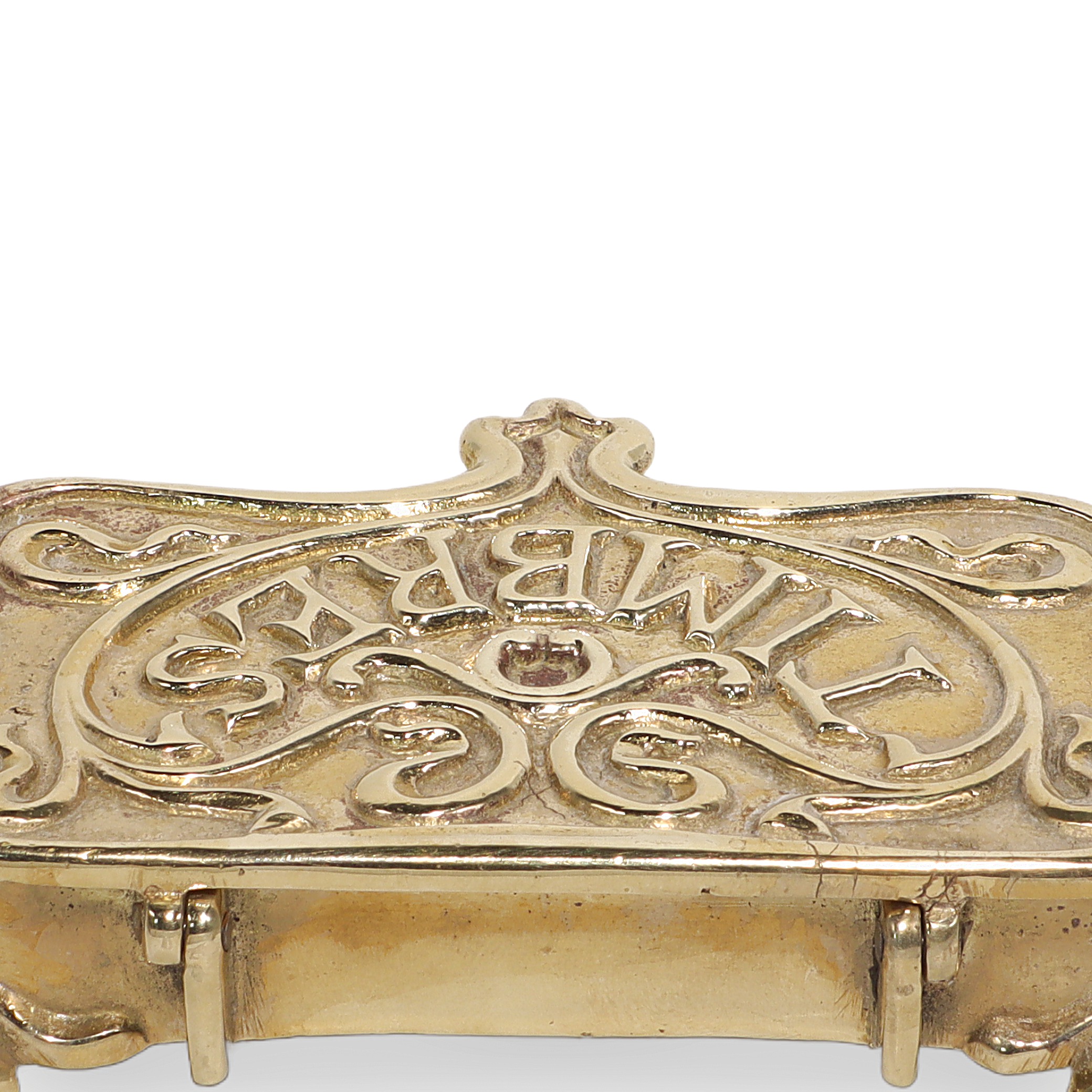 Brass stamp box close up showing ornate vintage design and embossed lettering