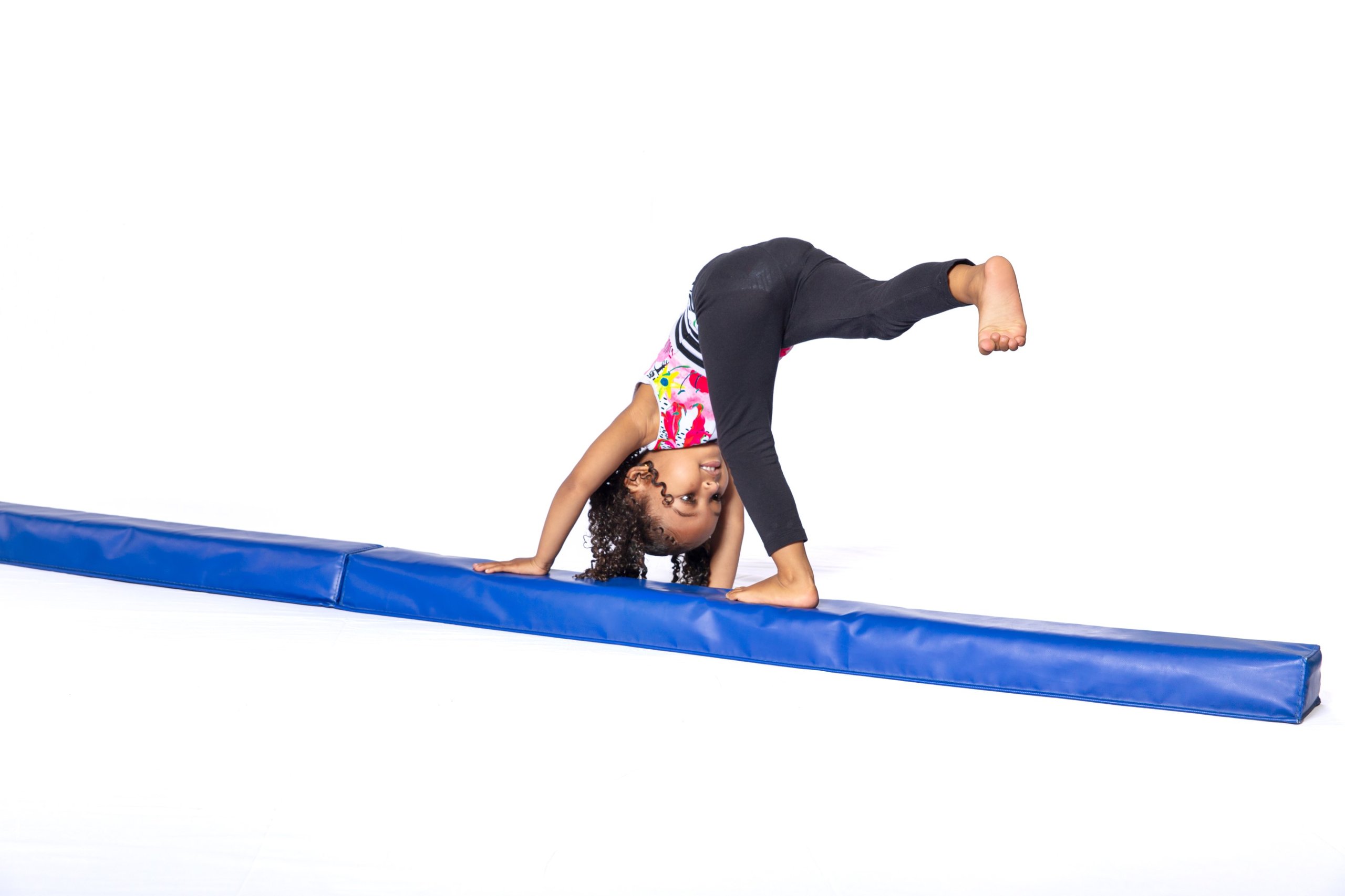 Young child crawling across floor balance beam kicking one leg out