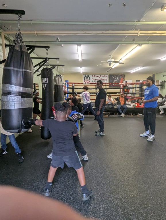Young boxer hitting heavy bag at D-Boys