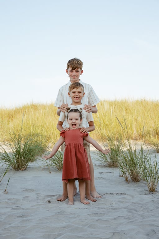 Three siblings posing on beach
