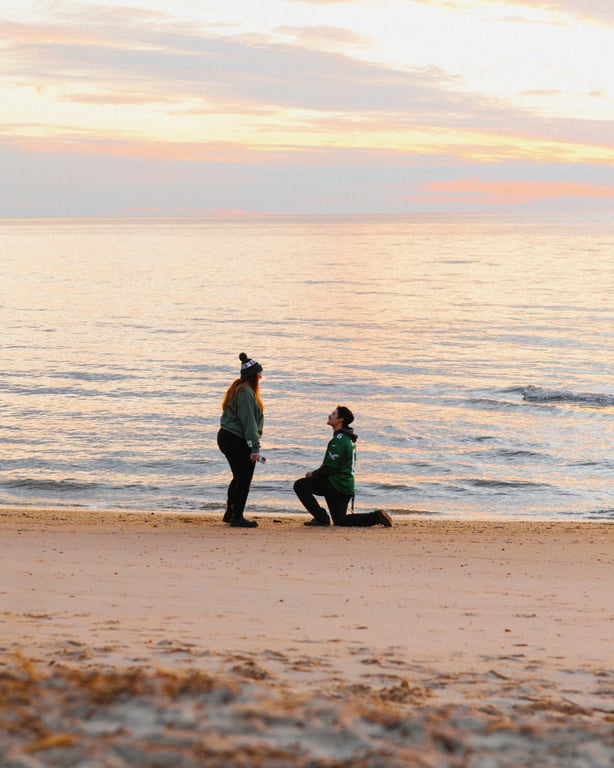 Man proposing on beach at sunset