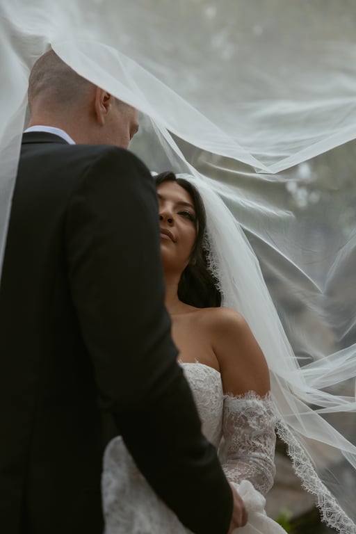 Bride and groom under veil