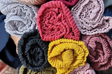 a person holding a bunch of cloth flowers