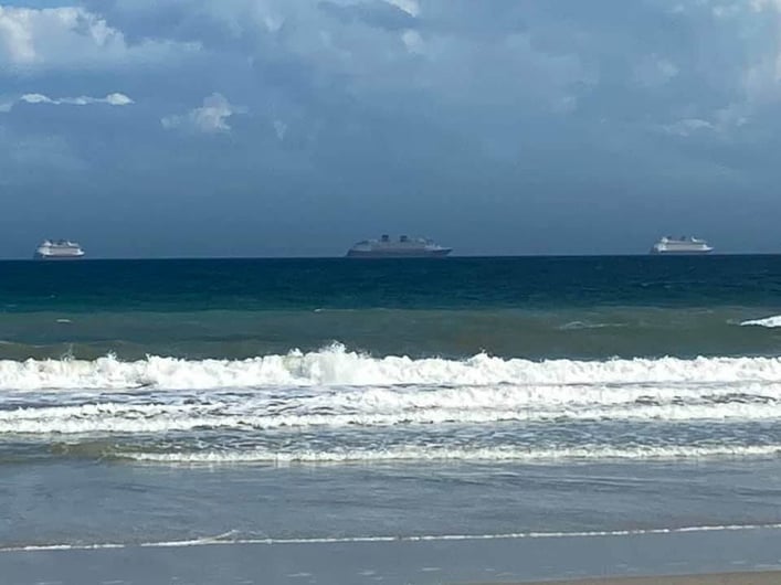 Disney Cruise Line ship on the horizon from the beach