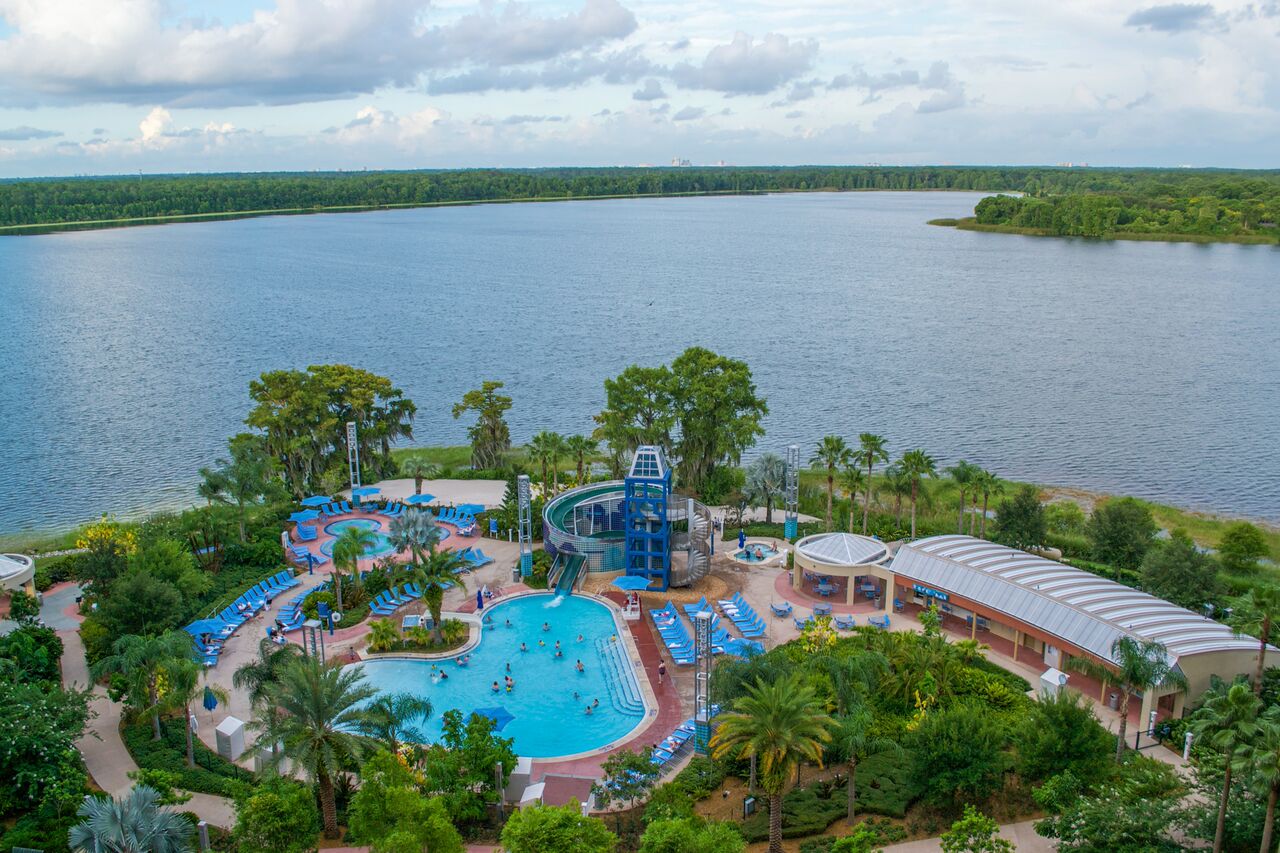 A waterslide feeds into the pool at Bay Lake Tower, surrounded by a lake