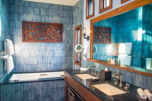 Blue tiles line the entire walls in the master bath of a bungalow