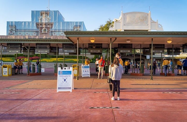 Small gathering of people waiting in line to enter Disney World.