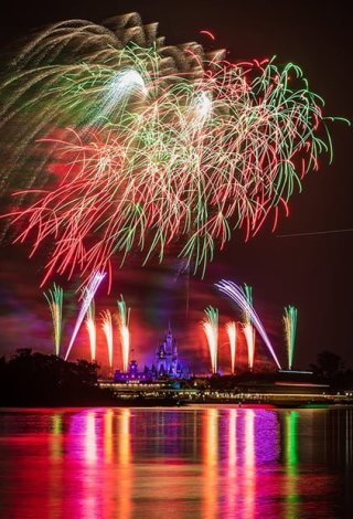 Fireworks exploding in the sky above the disney world castle