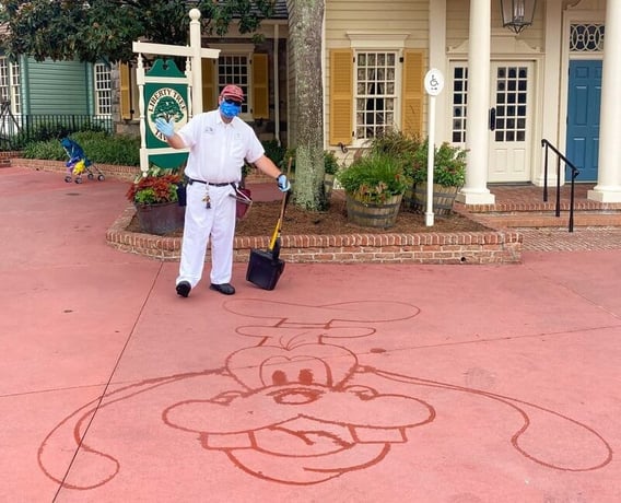 Disney Cast Member cleaning up at Magic Kingdom