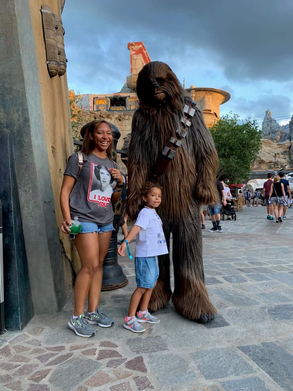 Chewbacca at Disney's Galaxy's Edge posing with mother and daughter