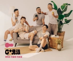 A group of men relaxes on a couch, each holding a drink and engaged in conversation.