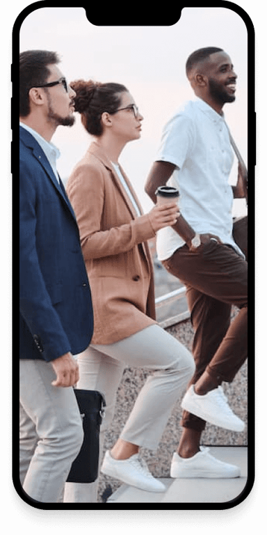 A group of coworkers smiling while walking up steps.